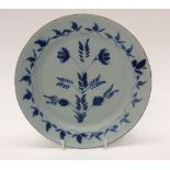 A tin glazed plate hand decorated with blue floral and foliate pattern to the centre and the rim