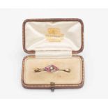 An Edwardian ruby and diamond brooch comprising square cut rubies and rose cur diamonds,