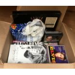 A box of Elvis memorabilia including records, cassettes, videos,