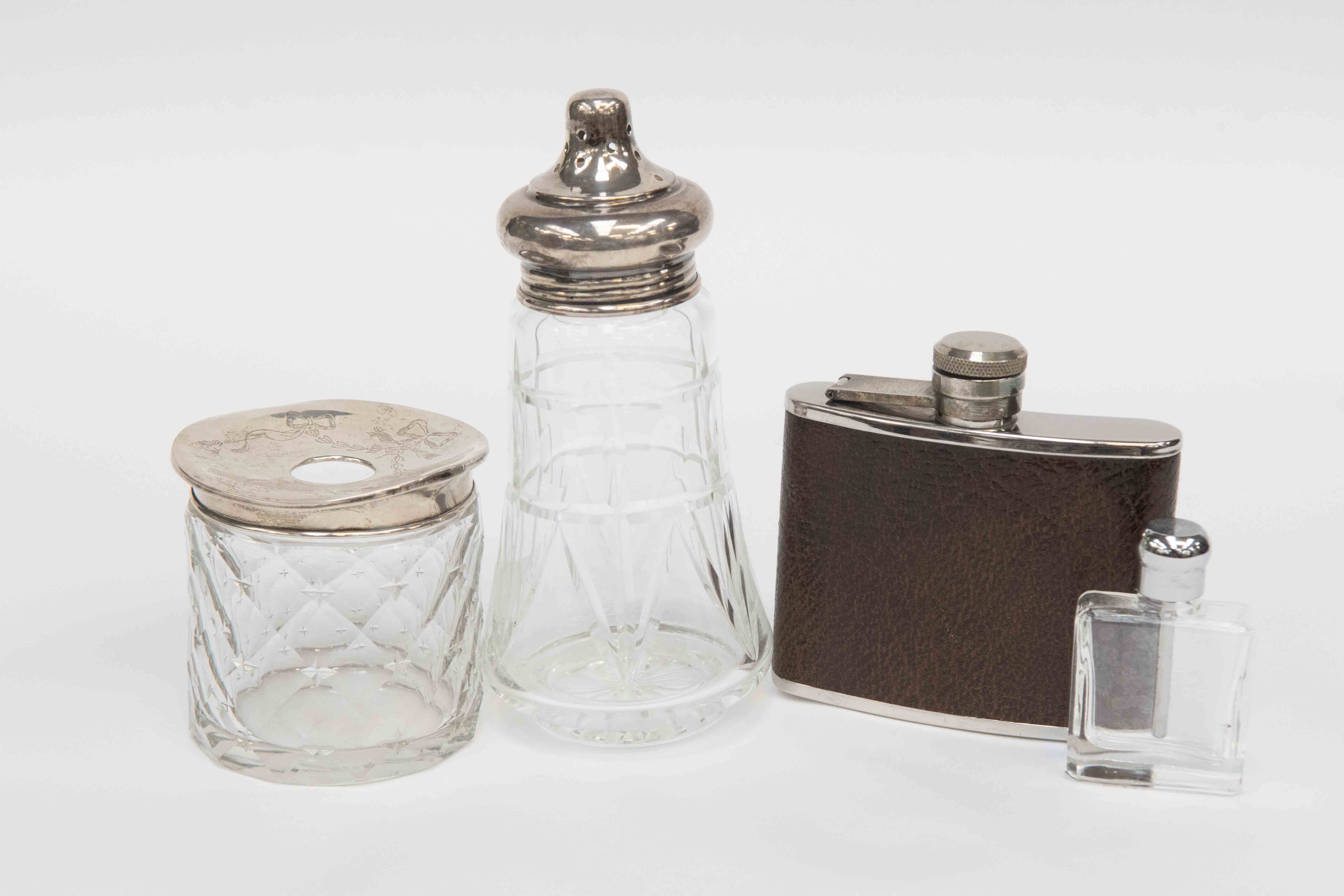 A silver lidded glass jar with diamond cut star detail, a silver topped sugar sifter London,