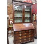 A George III oak bureau bookcase, the upper section with two glazed doors,