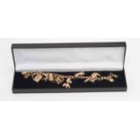 A 9ct gold charm Bracelet, with various 9ct gold and yellow metal charms including poodle,