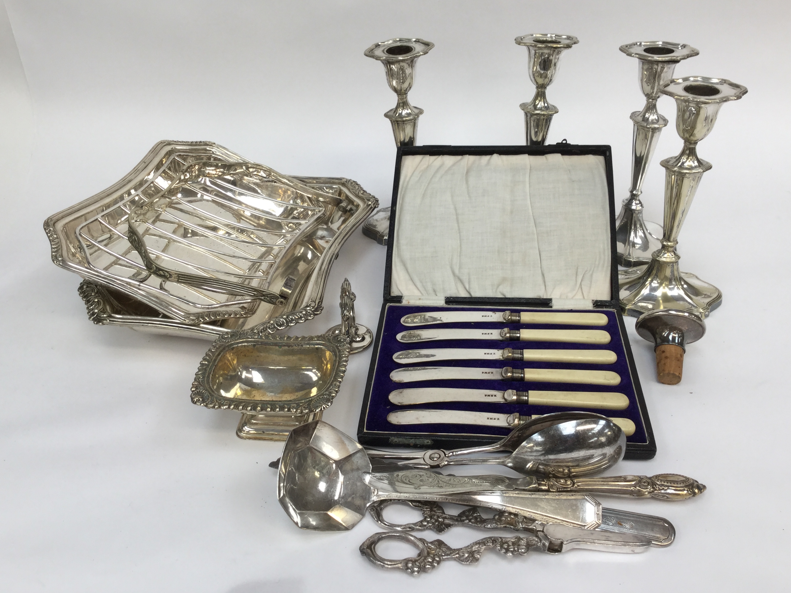 A set of four EP candlesticks, entree dish and caver, flatware etc, grape scisssors, open salt.