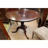 A George III mahogany tilt top tripod table; The circular top being made from one piece of timber,