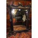 A Victorian ebonised scroll carved wall hanging mirror