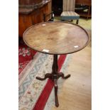 A George III mahogany circular topped tripod table, having a dished circular top,