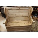 A 19th Century pine box settle having a panelled back and lidded seat.