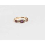 A Victorian ruby and diamond ring, three rubies in square settings, scroll/foliate shoulders,