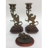 Pair of early 20th Century Wyvern brass figures in the form of candlesticks on wooden pliths with a