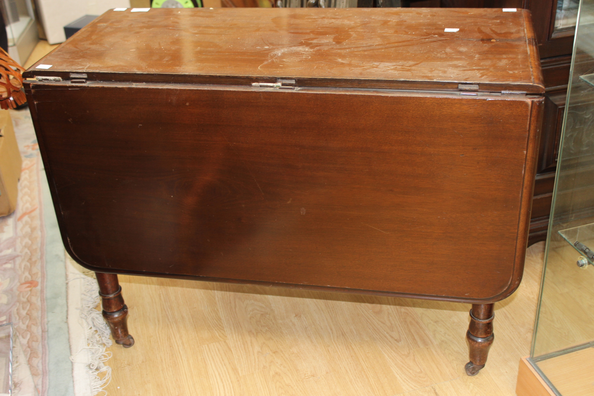 A Victorian mahogany drop leaf dining table fitted with a drawer for each side and turned legs.