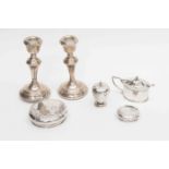 A collection of silverware, comprising: a pair of candlesticks; a pepperette; a mustard pot; lids,