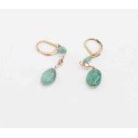 A pair of emerald earrings with two natural polished emerald drops with gold chain and bead