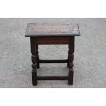 A 17th Century oak joined stool, circa 1650, plank seat with moulded edge, turned support,