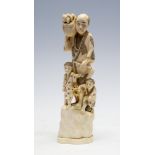 A Japanese ivory tusk carving okimono of a farmer carrying a basket with two infants, Meiji period,