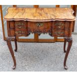 An 18th Century or later mahogany lowboy, having a shaped front, fitted with three drawers,