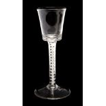 An 18th Century wine glass, having a tapering bowl, air twist stem, spreading base,