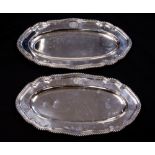 A pair of George V silver platters, elongated oval form, ogee gadrooned borders, with coat of arms,