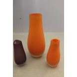 Three Catherine Hough designed Dartington Studio glass vases, two in orange, and one in Amethyst.