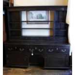 A George II oak dresser and rack, the open backed rack with six divided shelves,