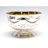 A George V silver rose bowl embossed ribbons, bows and swags, with oval vacant cartouches,