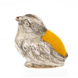 An Edwardian silver pin cushion cast in the form of a chick, yellow velvet back,