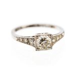 An Art Deco diamond and platinum solitaire ring, six graduated diamonds to shoulders,