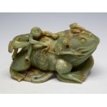 A large Chinese carved jade figure of a toad with a monkey on its back,