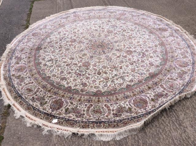 A circular Persian design cream ground rug,