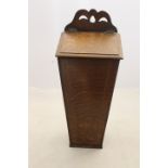 A 19th Century oak candle box, pierced fretwork above a tapered rectangular hinged box,