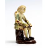 A mid 18th Century English Whieldon type pottery model of a seated cobbler, circa 1750, height 11.