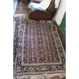 A medium sized woollen rug, on a red ground, floral patterned with a blue border, 250cm long,