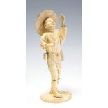 A Japanese ivory okimono of a man wearing a rice hat and holding a fan, Meiji period, 1868-1912,