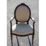 A late 19th Century carved French style open armchair, with an oval back and seat,