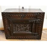 A 17th Century and later oak cupboard with a single door, carved initials R.M.S.