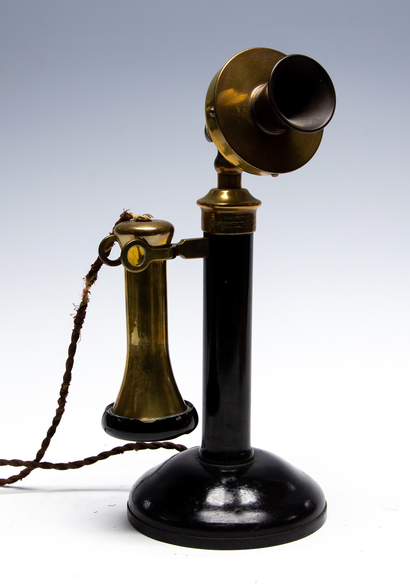 A circa 1920's candlestick telephone, black metal with brass fittings and vulcanite mouthpiece,