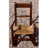 Child's 19th Century Lancashire rush seated rocking chair with turned back rest and arm rests.