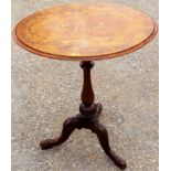 A mid Victorian walnut tripod table, the figured top raised on a baluster turned column,