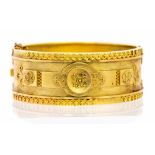 A Victorian Etruscan style yellow metal bangle,