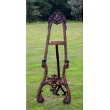 A late 19th Century mahogany picture easel, with a carved wooden folio box accessory,
