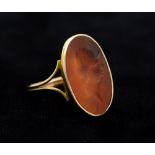 A orange agate oval intaglio ring, the intaglio possibly Roman, carved with gladiator style head,