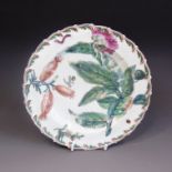 A Chelsea plate with a moulded rim border painted in the Hans Sloane style with leaves and flowers,