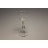 A late 18th Century cut glass wine glass, having a lipped bowl, facet cut and knopped stem,