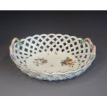 A Chelsea Derby oval pierced basket, painted with cut fruit and insects, twin rope twist handles,