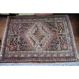 An early 20th Century oriental rug, geometric design of stylized animals in green,