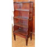 A George III mahogany waterfall front freestanding bookcase, circa 1810, brass side handles,