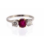 A ruby and diamond three-stone platinum ring, central ruby approx 6mm x 5mm,