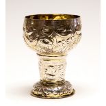 A German 17th Century parcel-gilt goblet, the bowl chased with ribbon tied fruit and flowers ,