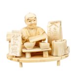 A Japanese ivory okimono of a scribe with his wares, Meiji period, 1868-1912, signed,