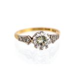 A diamond solitaire 18ct gold ring, with diamond set shoulders,