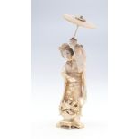 A Japanese ivory okimono of a mother holding an infant upon her shoulder, MEIJI PERIOD 1868-1912,